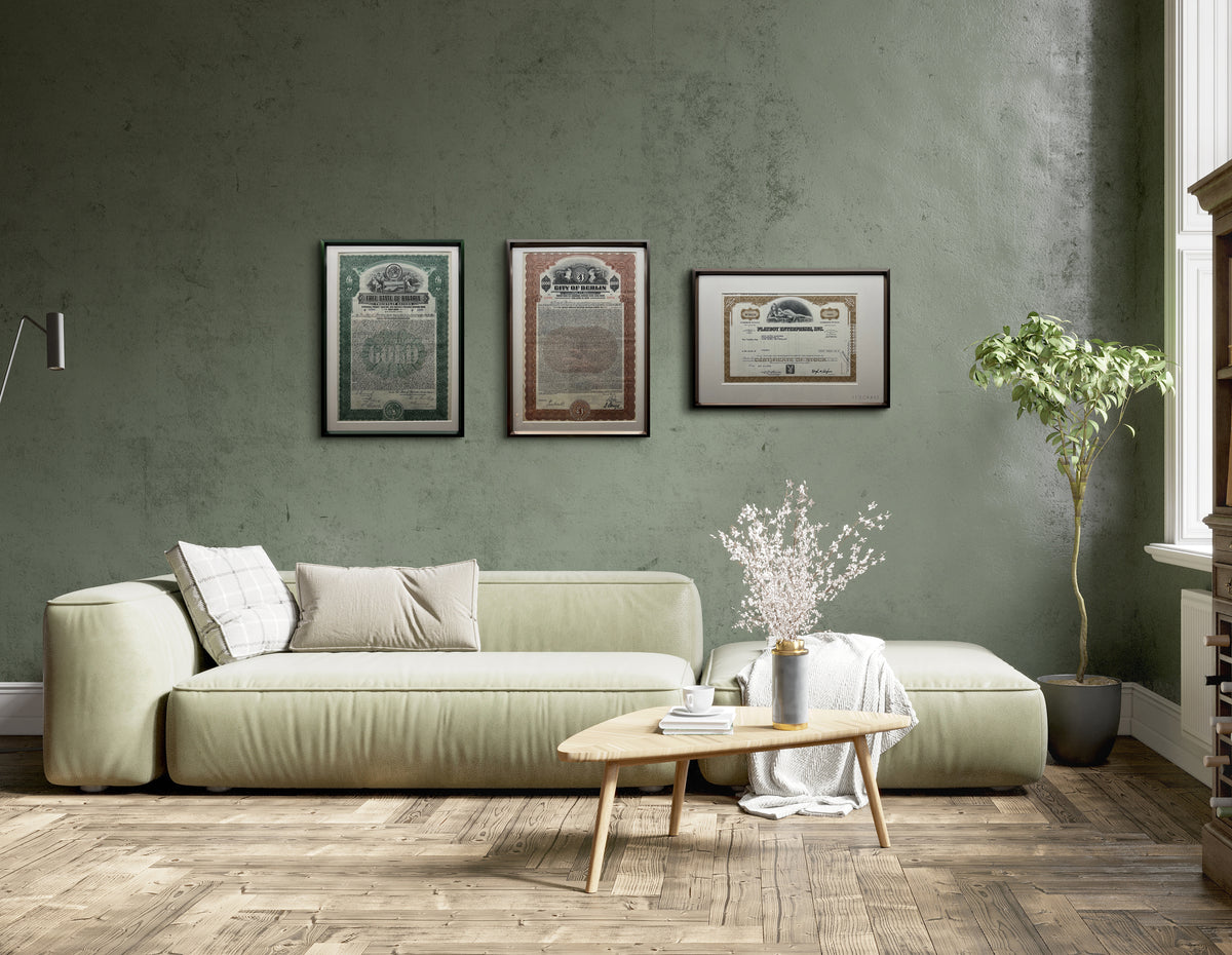 Three framed Stockart certificates on a green living-room wall